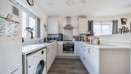 Modern white kitchen with appliances, wooden worktops and appliances.