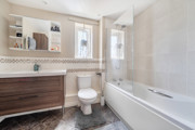 Bathroom with a bathtub, toilet, sink and mirrored cabinet.