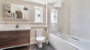 Bathroom with a bathtub, toilet, sink and mirrored cabinet.