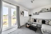 Living room with patio doors, a sofa and framed photos on the wall.