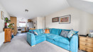 Open-plan living and dining area with blue sofa and kitchen.