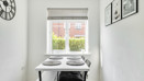 Dining area with a table and chairs positioned beneath a window.