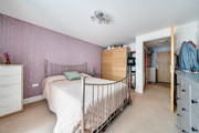 Bedroom with double bed, wardrobes and chest of drawers.