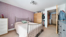 Bedroom with double bed, wardrobes and chest of drawers.