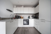 White fitted kitchen with integrated oven, hob, cupboards and worktops. (1)