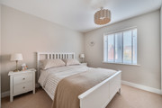 Bedroom with double bed, bedside tables and window with blinds.