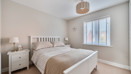 Bedroom with double bed, bedside tables and window with blinds.