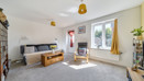 Living room with sofa, shelving, television and patio door to the garden.