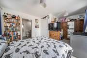 Bedroom with double bed, bookcase, wardrobe and neutral decor.