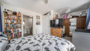 Bedroom with double bed, bookcase, wardrobe and neutral decor.