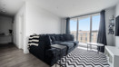Open-plan living area with corner sofa, patterned rug and balcony doors.