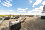 Roof terrace with outdoor seating, tables and surrounding views.