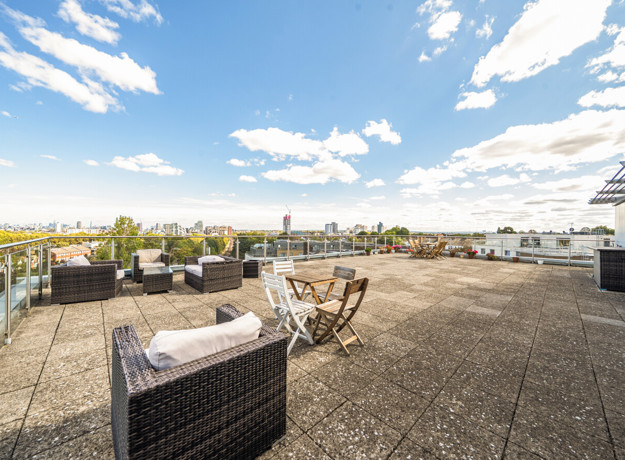 Roof terrace with outdoor seating, tables and surrounding views.