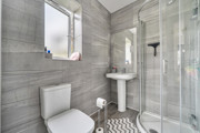 Ensuite with a toilet, pedestal sink and glass shower enclosure.