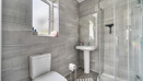 Ensuite with a toilet, pedestal sink and glass shower enclosure.