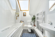 Bathroom with bath, toilet, sink and heated towel rail.