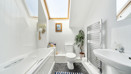 Bathroom with bath, toilet, sink and heated towel rail.