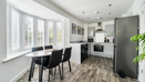 Open-plan kitchen and dining area with table, chairs and window blinds.