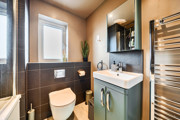 Contemporary bathroom with shower, basin, mirror, WC and towel rail.