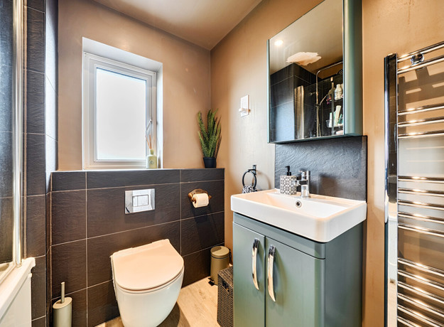 Contemporary bathroom with shower, basin, mirror, WC and towel rail.