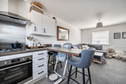Open-plan kitchen and living area with breakfast bar and seating.