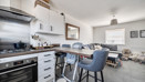 Open-plan kitchen and living area with breakfast bar and seating.