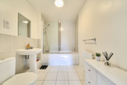 Bathroom with bath, shower screen, wash basin and radiator.