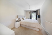 Bedroom with a double bed, bedside tables, wardrobe and window.