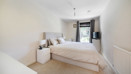 Bedroom with a double bed, bedside tables, wardrobe and window.
