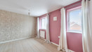 Living room with patterned wallpaper, pink walls, and windows with light curtains.