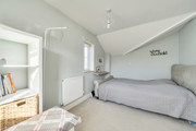 Bedroom with double bed, radiator and sloped ceiling.