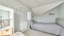 Bedroom with double bed, radiator and sloped ceiling.