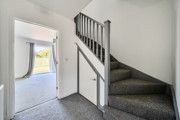 Entrance hall with staircase and doorway to living room.