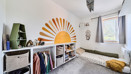 Bedroom with sun mural, storage, floorbed and window.