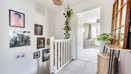 Landing with framed artwork, staircase, radiator and carpeted door.
