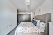 Bedroom with double bed, bedside tables and fitted wardrobe doors.