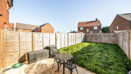 Rear garden with lawn, patio seating area and fenced boundaries.