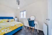 Bedroom with double bed, dressing table, chair and window.