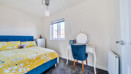 Bedroom with double bed, dressing table, chair and window.