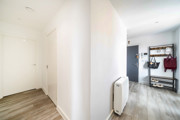 Entrance hallway with wood-effect flooring and storage space.