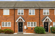 Red-brick terraced houses with front gardens and black front doors.