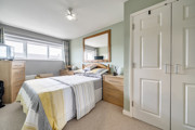 Bedroom with double bed, build-in wardrobe and window.