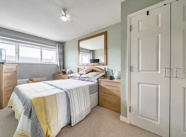 Bedroom with double bed, build-in wardrobe and window.