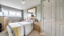 Bedroom with double bed, build-in wardrobe and window.