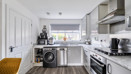 Kitchen with fitted units, appliances, wooden-effect floor and window.