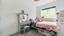Children's bedroom with a single bed, dressing table and window.