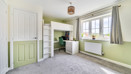 Bedroom with bunk bed, desk, window and carpeted floor.