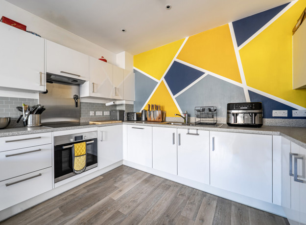 Fitted kitchen with oven, hob, worktops and wall cabinets.