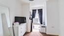 Bedroom with chest of drawers, vanity table, mirror, desk and window.