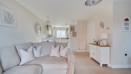 Open-plan living area with sofa, sideboard and decorative wall mirrors.